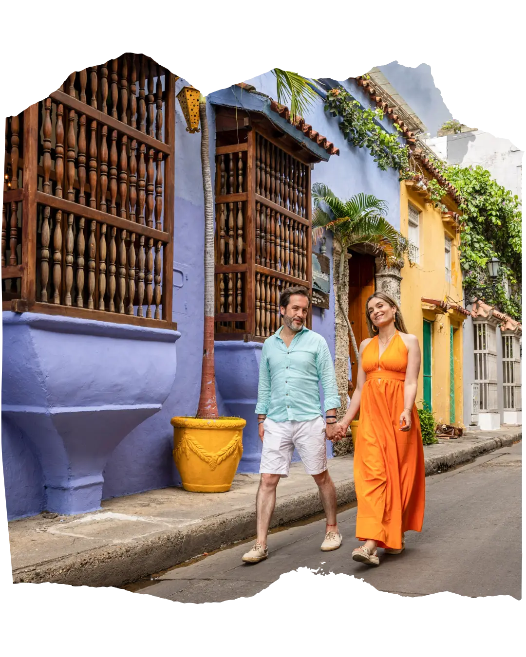 Carol y Carlos caminando de la mano por una calle colorida de Cartagena