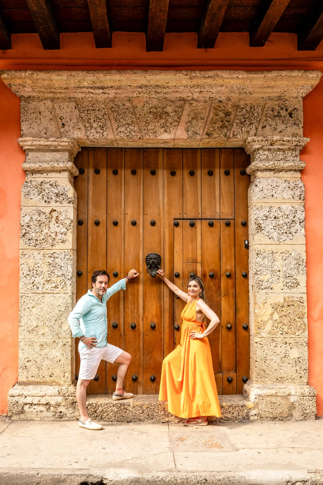 Carol y Carlos frente a una gran puerta de madera colonial
